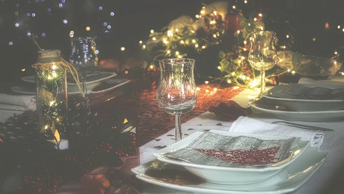 Dukat julbord med vinglas, vita tallrikar och ljusslingor